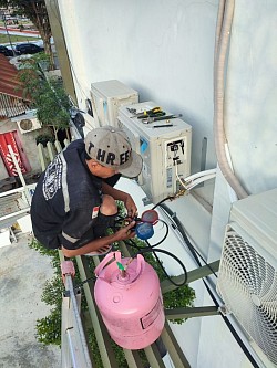 Teknisi sedang mengisi freon ac